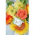 Ceramic Jug Arranged with Mixed Orange and Yellow Shades of Flowers with Greenery